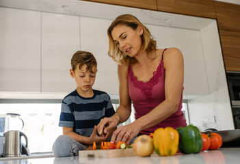 Mother and son cooking together in kitchen
