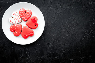 St Valentine's Day cookies in shape of heart on plate on black background top view copy space