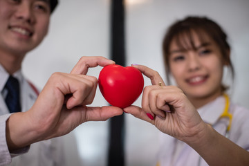doctor holding red heart at hospital. medical, healthcare, cardiology concept