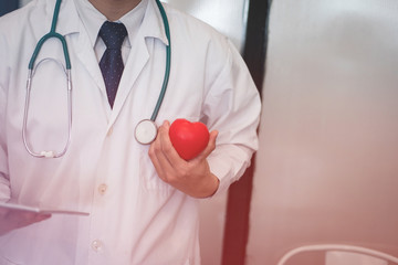 doctor holding red heart at hospital. medical, healthcare, cardiology concept