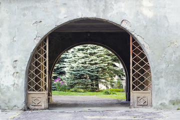 Old metal gate in wall and passage to garden