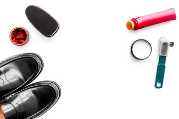 Shoe care products. Leather men shoes, shoe polish, brushes, wax on white background top view copy space