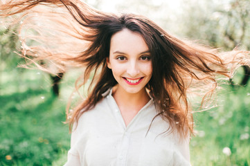 Naklejka premium Spring is in the air. Nature ressurection after long sleep. Tender woman portrait in Japanese blooming emerald garden. Femininity of smiling happy cute girl with unusual lifestyle activity outdoor.