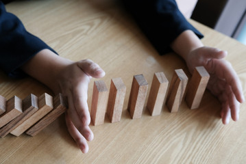 hand stopping effect of domino continuous toppled. busineeman protecting falling wood block....