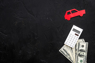 Car credit concept. Money and calculator near car silhouette on black background top view copy space