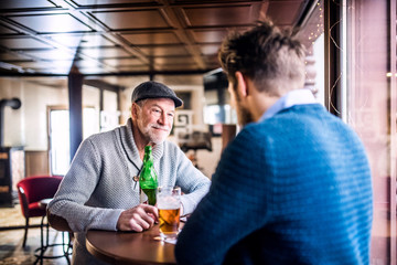 Senior father and his young son in a pub. - Powered by Adobe