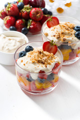 Assorted fresh fruit with custard on white table, vertical, top view
