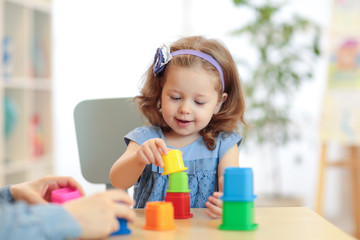 Kid playing developmental toys at home or kindergarten