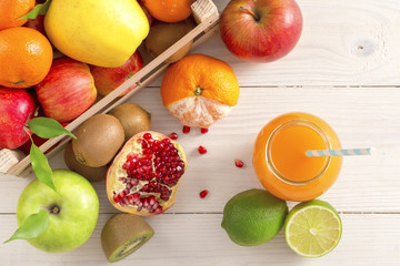 A glass of juice with a straw from different fruits