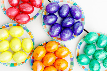 Easter eggs on wooden background. Colorful eggs in different colors - red, yellow, orange, purple and green.