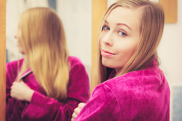 Happy woman looking at her reflection in mirror