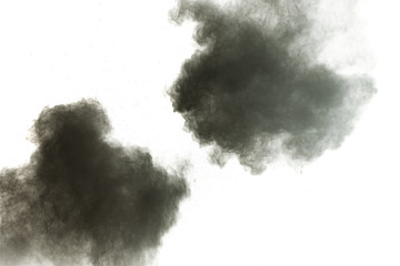 Black powder explosion against white background.The particles of charcoal splatted on white background. Closeup of black dust particles explode isolated on white background.