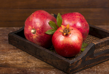 Fototapeta na wymiar Ripe pomegranate fruits on the wooden background
