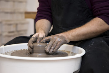 Artist makes clay pottery on a spin wheel