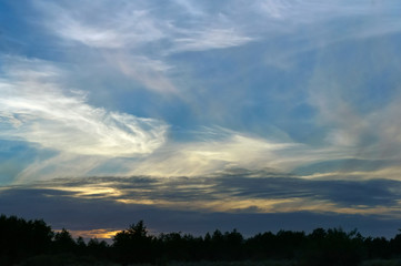 Red and purple sunbeams at sunset. The sun is setting over the horizon.