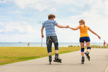 Young couple on roller skates riding outdoors