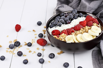 Healthy Breakfast Buddha Bowl with berries, coconut, bananas and granola.