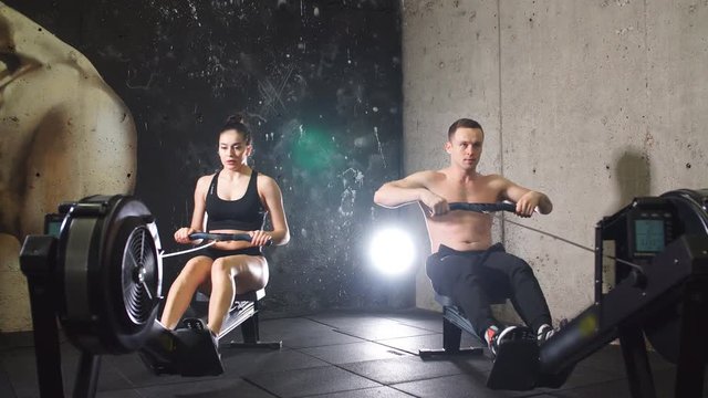 Athletes Working Out On Rowing Machine.
