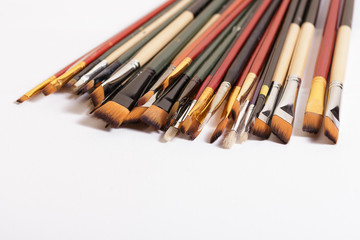 Professional brushes for artists lie on a white canvas