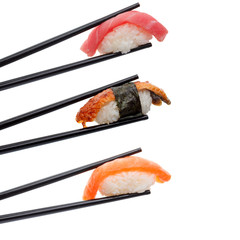 Japanese cuisine. Sushi in chopsticks isolated on white background.