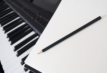 Piano keyboard, pen and sheet. Concept of composing song.