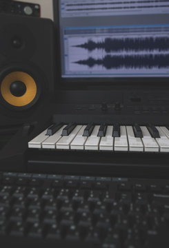 Home recording studio with professional monitors and midi keyboard.