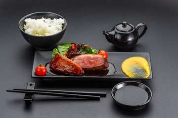 Duck meat with rice over dark background.
