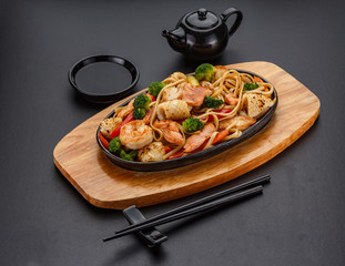 Udon noodels over dark background.