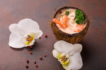 Tasty Shrimp soup with coconut milk, kaffir lime leaves, galangal, chilli and lemon grass in a coconut