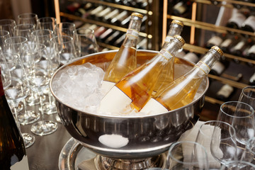 Bottles of orange wine in bowl with ice
