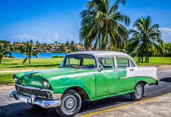 Obraz na płótnie Canvas Grüner amerikanischer Oldtimer mit weissem Dach parkt in Varadero nahe des Strandes Kuba - HDR - Serie Cuba Reportage