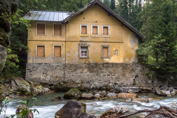 Fototapeta na wymiar Verfallendes Haus an einem Fluss im Wald