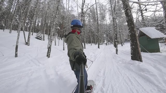 Snowboarder cable lfts through the forest