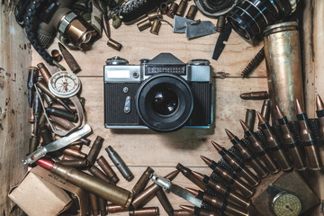 wooden box with vintage camera, bullets for automatic weapon, conceptual expression of the power of...