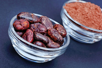 Cacao beans and powder in a transparent bowls