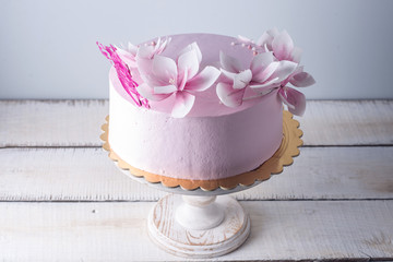 Beautiful pink wedding cake decorated with flowers. Concept of elegant holiday desserts