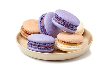 Plate vith violet and beige macarons on white