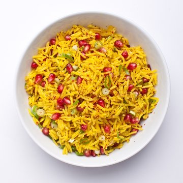 Top View Bowl Of Rice With Pomegranate Seeds On White Background