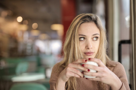 Blonde girl drinking a coffee