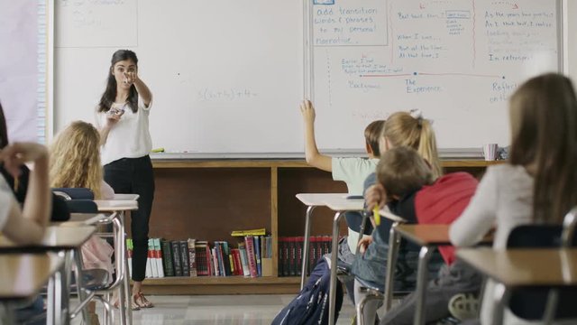 Panning shot of teacher questioning students in classroom / Provo, Utah, United States