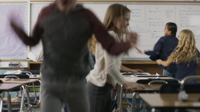 Frustrated teacher watching children in chaotic classroom / Provo, Utah, United States