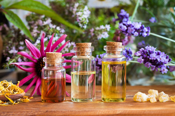 Bottles of essential oil with calendula, frankincense, echinacea, lavender