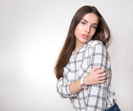 beautiful young woman with long hair wearing wrist watch posing on background with copy space