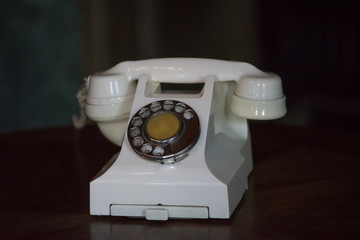 Vintage phone light beige with dialer on dark background.