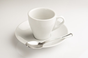 tazzina di caffè con cucchiaino su fondo bianco