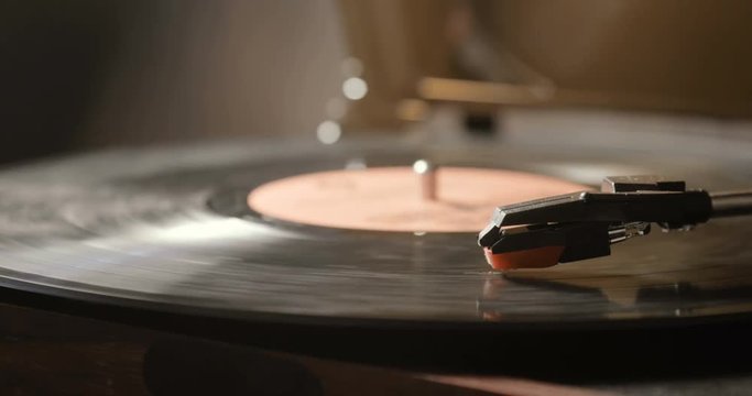 Close-up of using an antiquarian vinyl record player. turntable player,dropping stylus needle on vinyl record playing