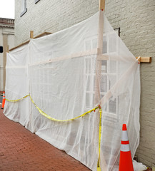 Plastic construction sheeting covering storefront undergoing renovation.