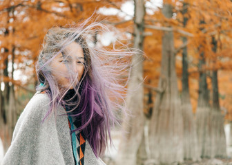 Portrait of woman in windy autumn weather.