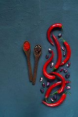 chili pepper, spices and beans on a blue concrete background, concept of healthy vegetarian food. Top view, free text space