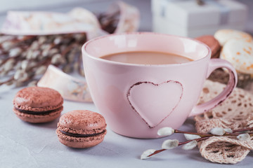 Pink coffee mug with sweet pastel french macaroons, gift box and pussy willow